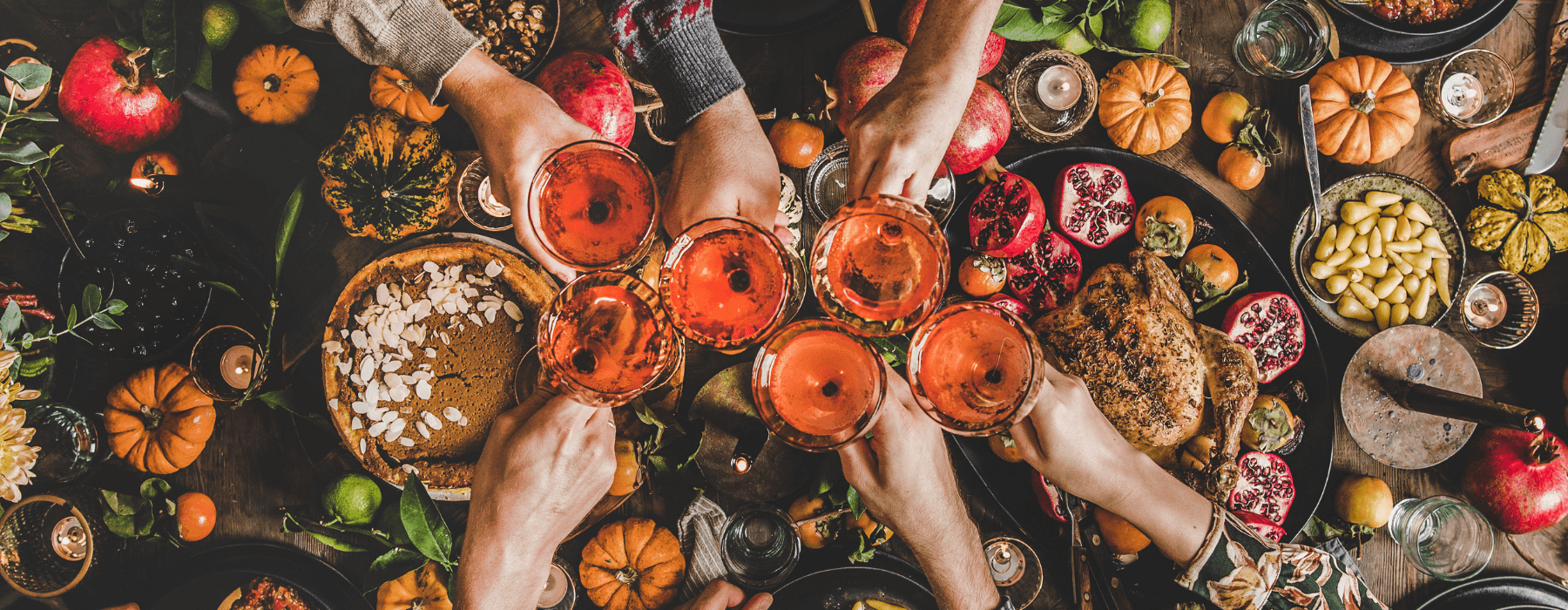  A festive Friendsgiving table filled with seasonal foods, colorful fruits, and friends toasting with glasses, creating a warm, celebratory atmosphere.