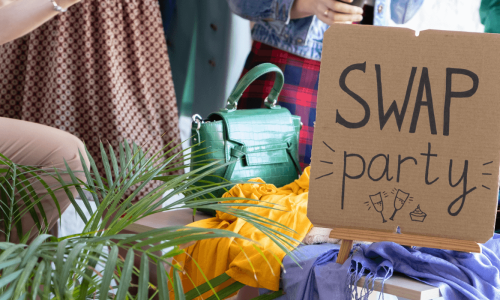 A clothing and accessory swap party setup with a sign reading 