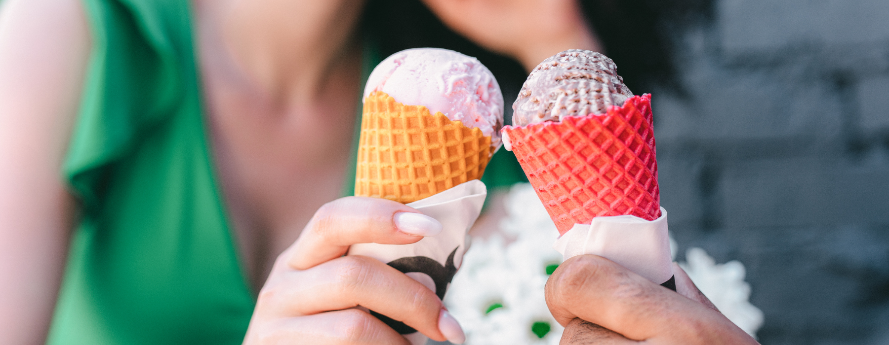 Two people holding colorful ice cream cones.