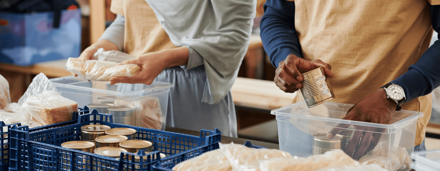 Volunteers packing canned food and bread into boxes, symbolizing community support and local aid efforts.